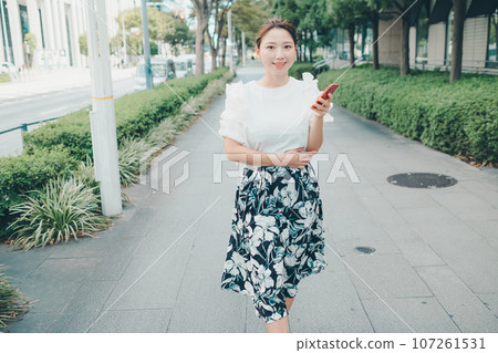 Photo of a young woman with a smartphone Photo of a young woman with a smartphone 107261531