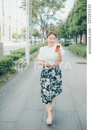 Photo of a young woman with a smartphone Photo of a young woman with a smartphone 107261533