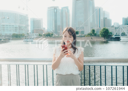 一名年輕女子使用智慧型手機的照片 107261944