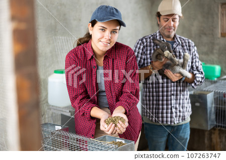 Family business - man and woman breed rabbits on farm Family business - man and woman breed rabbits on farm 107263747