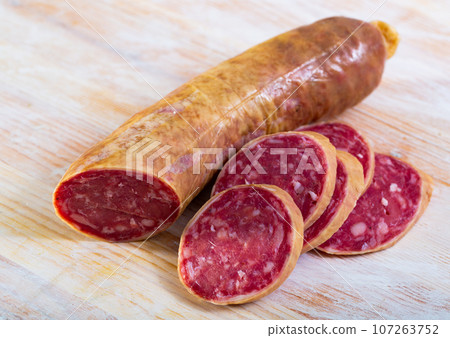 Salchichon spanish sausage slices on wooden desk Salchichon spanish sausage slices on wooden desk 107263752