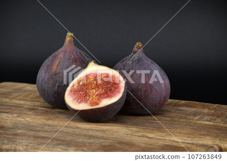 Rustic still life scene with figs in close up over black 107263849