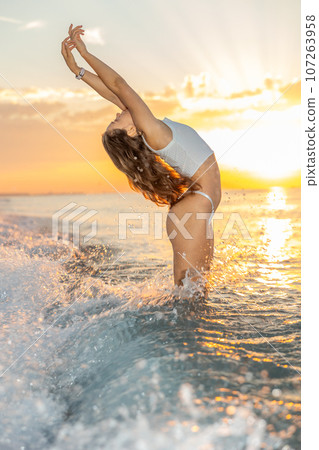Sexy girl in bikini playfully posing at beach on sunset Sexy girl in bikini playfully posing at beach on sunset 107263958