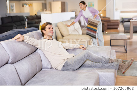 Man choosing couch in furniture store Man choosing couch in furniture store 107263968