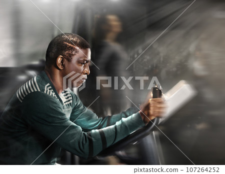 African man using exercise bicycle in gym 107264252