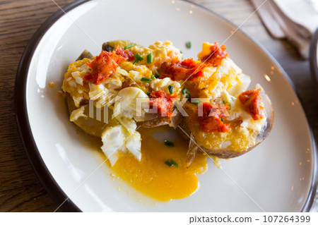 Potatoes al caliu with fried eggs and sobrassada Potatoes al caliu with fried eggs and sobrassada 107264399