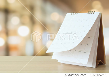 desk calendar on table with blurred bokeh background appointment and business meeting concept desk calendar on table with blurred bokeh background appointment and business meeting concept 107265758