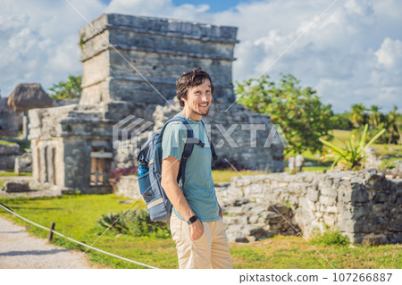 Male tourist enjoying the view Pre-Columbian Mayan walled city of Tulum, Quintana Roo, Mexico, North America, Tulum, Mexico. El Castillo - castle the Mayan city of Tulum main temple 107266887