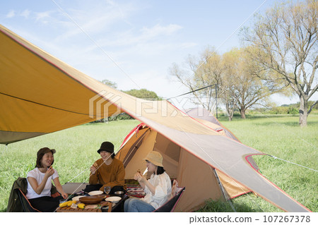 Outdoor image of young men and women enjoying camping 107267378