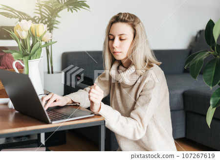 Young woman holding credit card and using laptop. 107267619