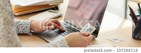 Female employee makes online payment for services on website 107268118