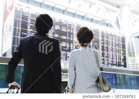 Young male and female businessmen going on a business trip from the airport 107269761
