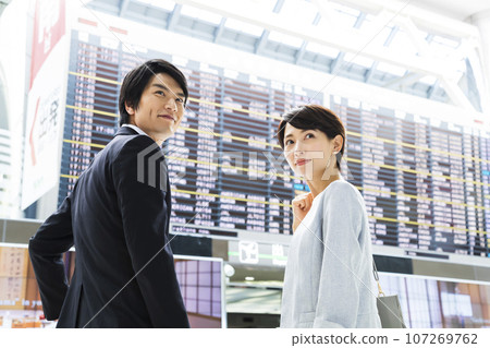 Young male and female businessmen going on a business trip from the airport Young male and female businessmen going on a business trip from the airport 107269762