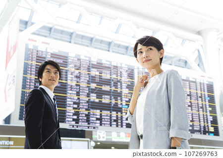 Young male and female businessmen going on a business trip from the airport Young male and female businessmen going on a business trip from the airport 107269763