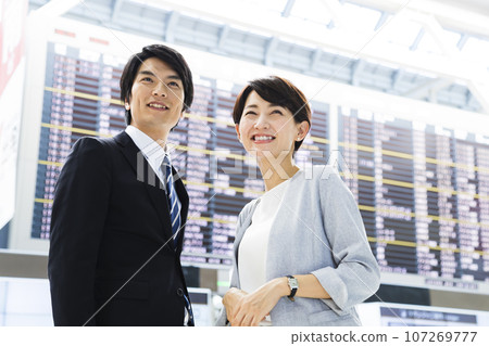 Young male and female businessmen going on a business trip from the airport 107269777