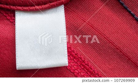 White blank laundry care clothes label on red polyester sport shirt background White blank laundry care clothes label on red polyester sport shirt background 107269909
