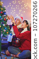couple decorate xmas tree 107270266