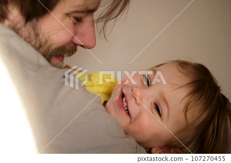 Happy Father with Daughter, Tiny Girl. One Year Baby Smiling, Laughing, Looking up at Daddy. Man Showing Affection to Child. Candid Real Emotion. Beard Dad and Little Kid. Authentic Family Lifestyle. 107270455