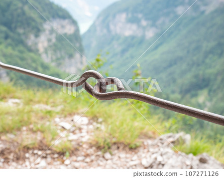 Rope and shackles anchored in hard dolomite limestone rock. Climbers path via ferrata. Rope and shackles anchored in hard dolomite limestone rock. Climbers path via ferrata. 107271126