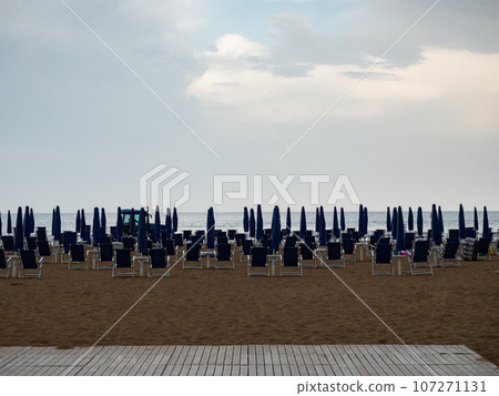 Closed beach parasol at empty seaside coast. Beach in Italy 107271131