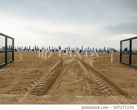 Wet sunbeds and umbrellas on the sea beach during rainy day. Wet sunbeds and umbrellas on the sea beach during rainy day. 107271138