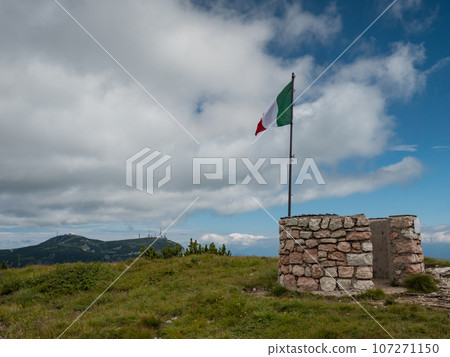Italian flag at Canfedin view. Summer meadow close to peak of Gazza mountain Italian flag at Canfedin view. Summer meadow close to peak of Gazza mountain 107271150