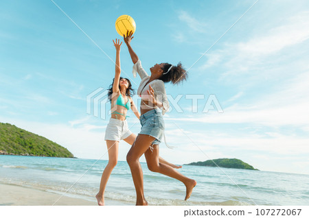 beautiful woman playing ball on the beach. 107272067