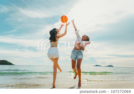beautiful woman playing ball on the beach. 107272069
