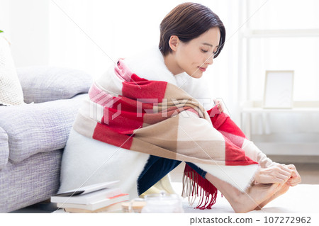 A woman warming her cold feet 107272962