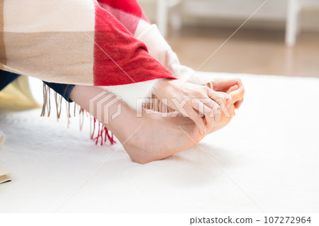A woman warming her cold feet A woman warming her cold feet 107272964