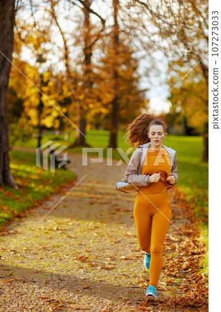 fit 40 years old woman in fitness clothes in park jogging fit 40 years old woman in fitness clothes in park jogging 107273033