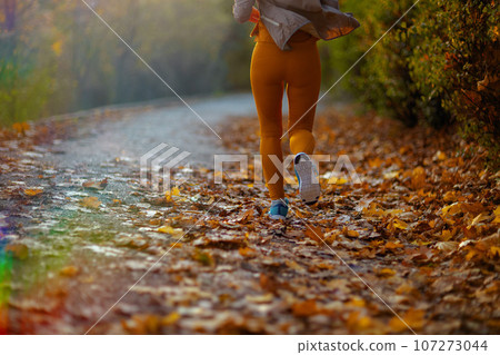 woman in fitness clothes in park jogging 107273044