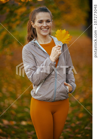 Portrait of smiling modern woman in fitness clothes in park 107273048