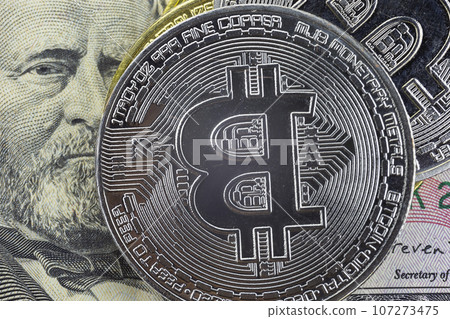 Bitcoin coins lie on a fifty dollar bill Bitcoin coins lie on a fifty dollar bill 107273475
