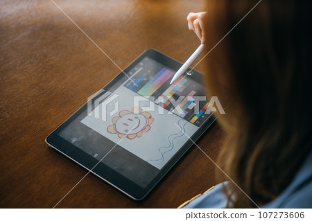 Lifestyle creative hobby woman digital artist draws a digital picture on digital tablet at cafe shop, Asian female artist illustrator painting drawing on touch pad digital tablet with stylus pen 107273606