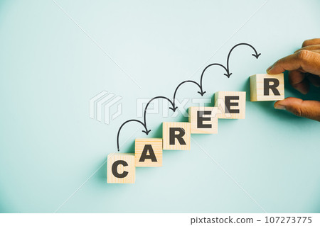 Hand delicately placing a wooden cube block with word CAREER on vibrant blue background, offering ample copy space for text. Illustrating the concept of business career planning growth towards success 107273775