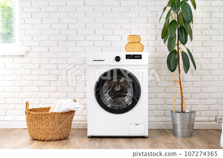 Washing machine and basket in a laundry room 107274365