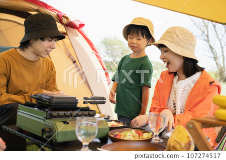 Outdoor image of a family enjoying camping food 107274517