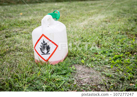 Fire danger sign. Plastic can in cut grass Fire danger sign. Plastic can in cut grass 107277247