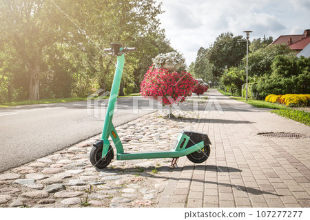 Electric scooter parked on the side of the street. Rental services Electric scooter parked on the side of the street. Rental services 107277277