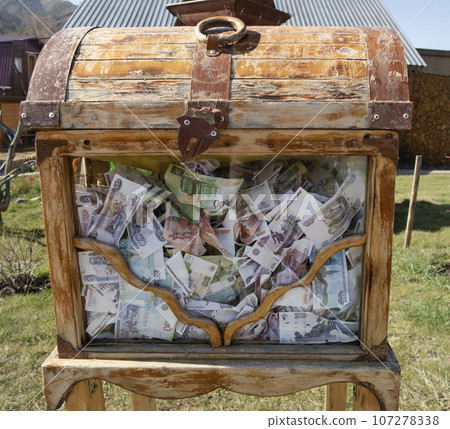 An old wooden chest with a glass wall for donations stuffed with Russian money 107278338