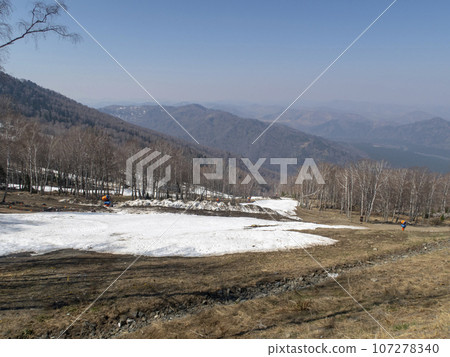 Melting snow on a ski slope in the spring in the Altai Mountains 107278340