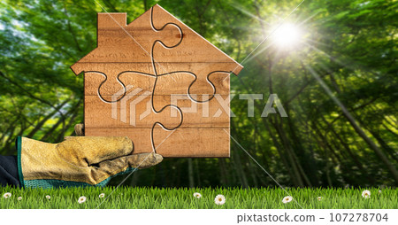 Gloved Hand Holding a Small Wooden House Made of Puzzle Pieces Gloved Hand Holding a Small Wooden House Made of Puzzle Pieces 107278704