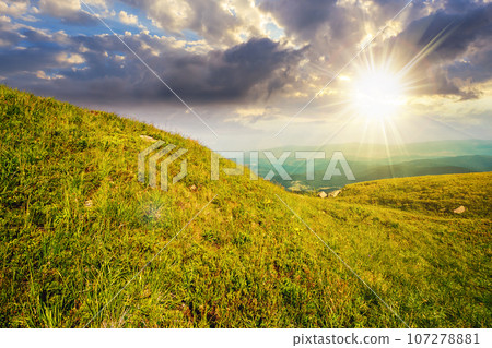 green grass on hillside meadow in high mountains under the cloudy blue sky at sunset. beautiful countryside scenery in evening light green grass on hillside meadow in high mountains under the cloudy blue sky at sunset. beautiful countryside scenery in evening light 107278881