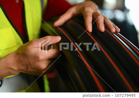 Closeup view of man worker checking quantity of tubes in storehouse 107279495
