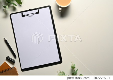 Flat lay, top view clipboard with blank paper, pen, coffee cup and eucalyptus branches on white background Flat lay, top view clipboard with blank paper, pen, coffee cup and eucalyptus branches on white background 107279707