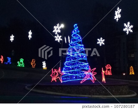 Christmas illumination Christmas tree carriage fountain white blue on dark background Christmas illumination Christmas tree carriage fountain white blue on dark background 107280187