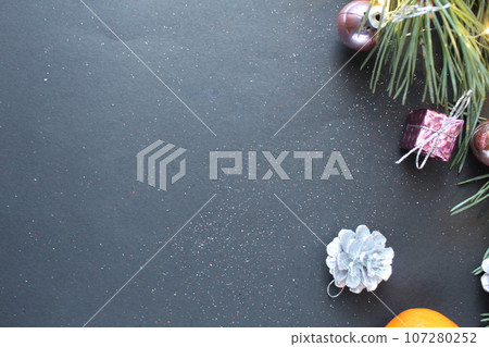 a branch of spruce spruce Christmas trees next to the tangerine cones and lights. Top view with space for text and copyspace. Background Christmas New Year 107280252