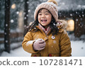Joyful Asian Toddler Laughing in the Snow, Catching Snowflakes with Gloves" 107281471