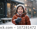 Joyful Asian Toddler Laughing in the Snow, Catching Snowflakes with Gloves" 107281472